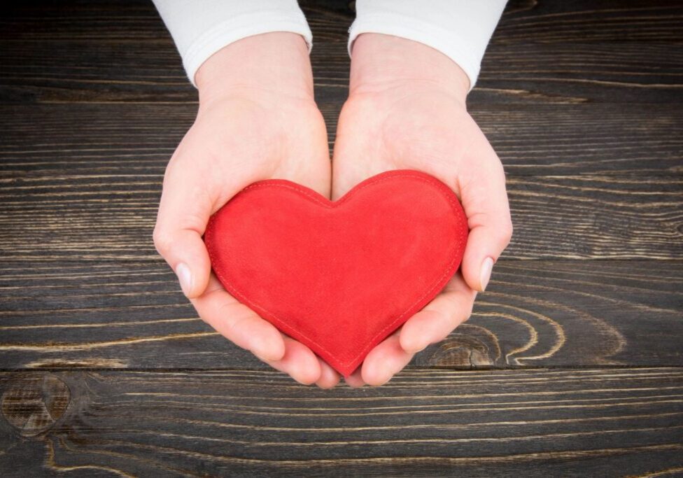 A Person Holding a Red Color Heart in Hand